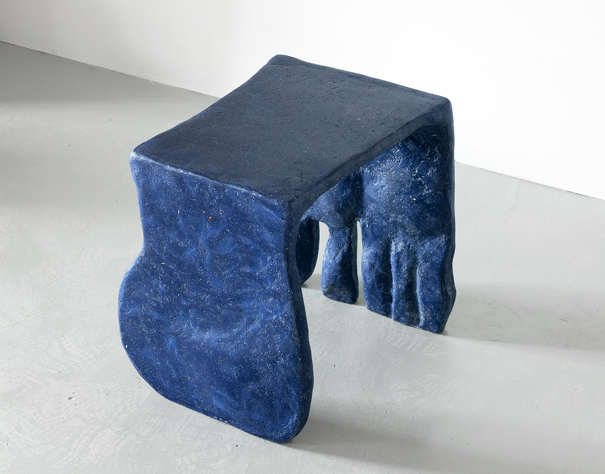Roommates by Barbora Žilinskaite — A hand-sculpted composite stool with anthropomorphic character, its organic torso and four tapered legs suggesting bodily presence rather than utilitarian...
