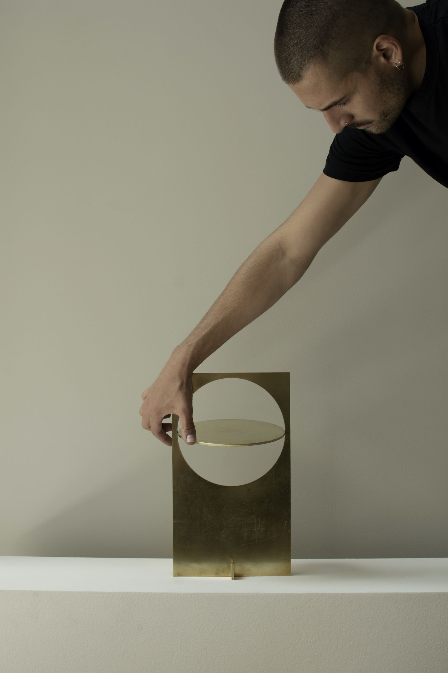 OBJ-01 by Manu Bañó — OBJ-01 lighting fixture mounted on white surface, photographed in direct interaction with human hand.