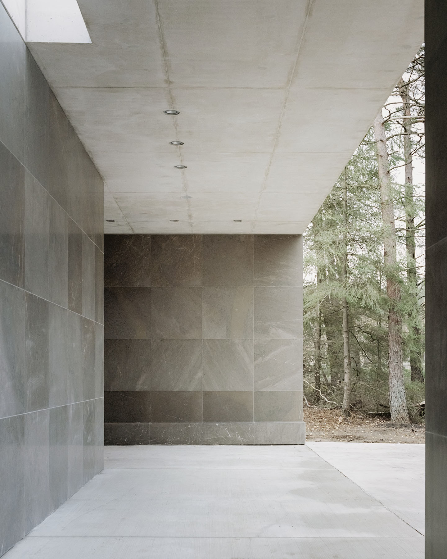 Loenen Pavilion by KAAN Architecten — A monolithic concrete pavilion frames the forest beyond through a continuous horizontal glazing plane.