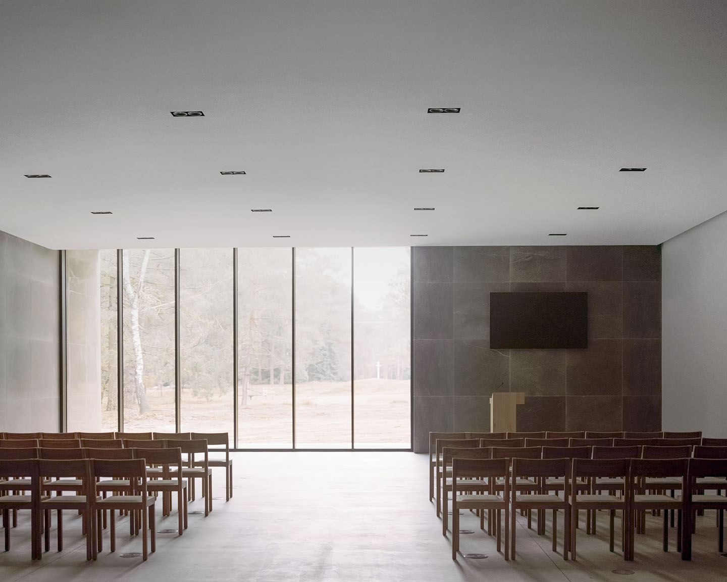 Loenen Pavilion by KAAN Architecten — The interior of the Loenen Pavilion presents a rectilinear volume defined by a continuous concrete ceiling punctuated by linear recessed lights and flanked...