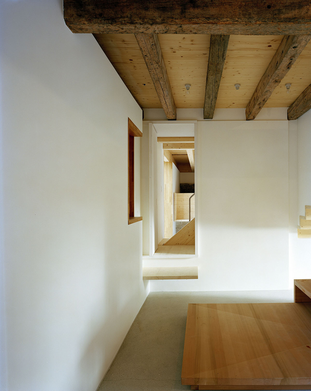 2 Houses in Chigny by Dieterdietz.org — A long corridor with white plaster walls and timber beam ceiling creates a linear passage through the interior.