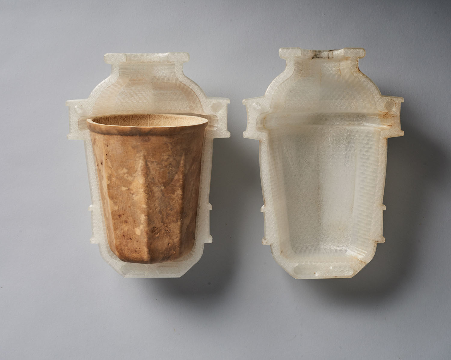 Biodegradable HyO-Cup by Crème — Overhead view of the HyO-Cup prototype showing a matched pair of plaster molds with contrasting finishes.