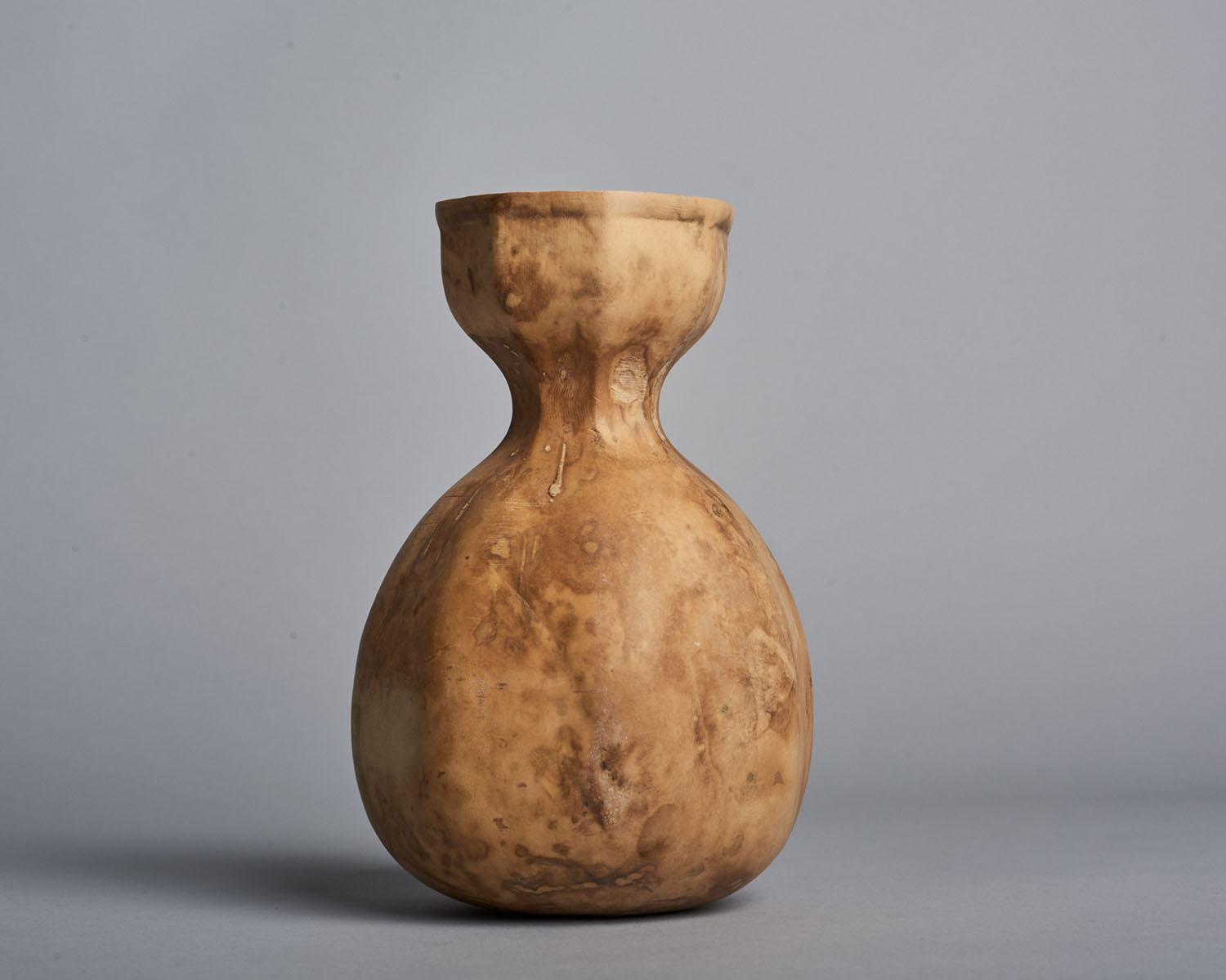 Biodegradable HyO-Cup by Crème — A single dried gourd vessel photographed against a neutral grey backdrop, demonstrating the HyO-Cup prototype's bulbous form and material qualities.