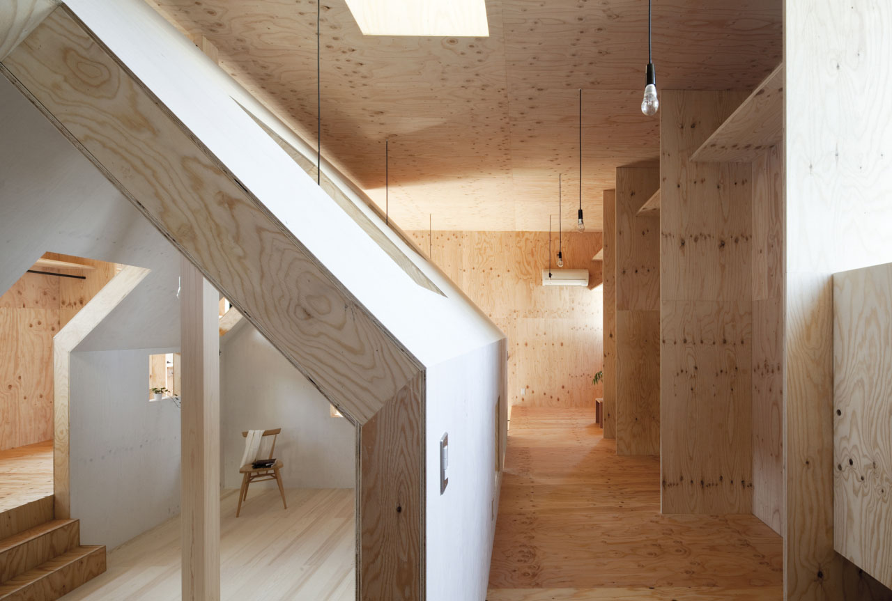Ant-house by mA-style Architects — A corridor lined with stacked plywood storage boxes of varying wood tones runs through the center of the Ant-house interior.