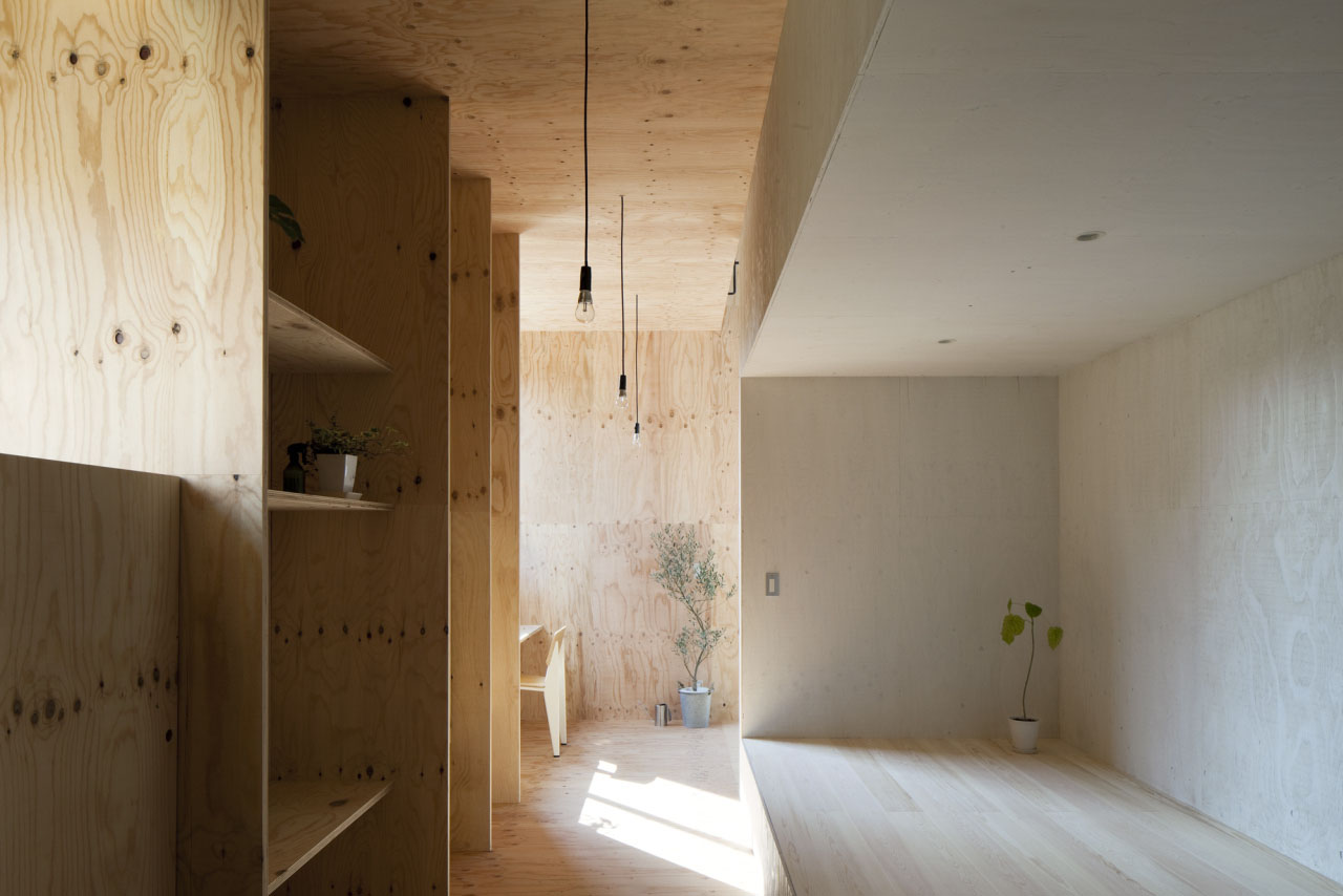 Ant-house by mA-style Architects — A corridor interior lined with stacked plywood storage boxes in varying wood tones along the left wall.