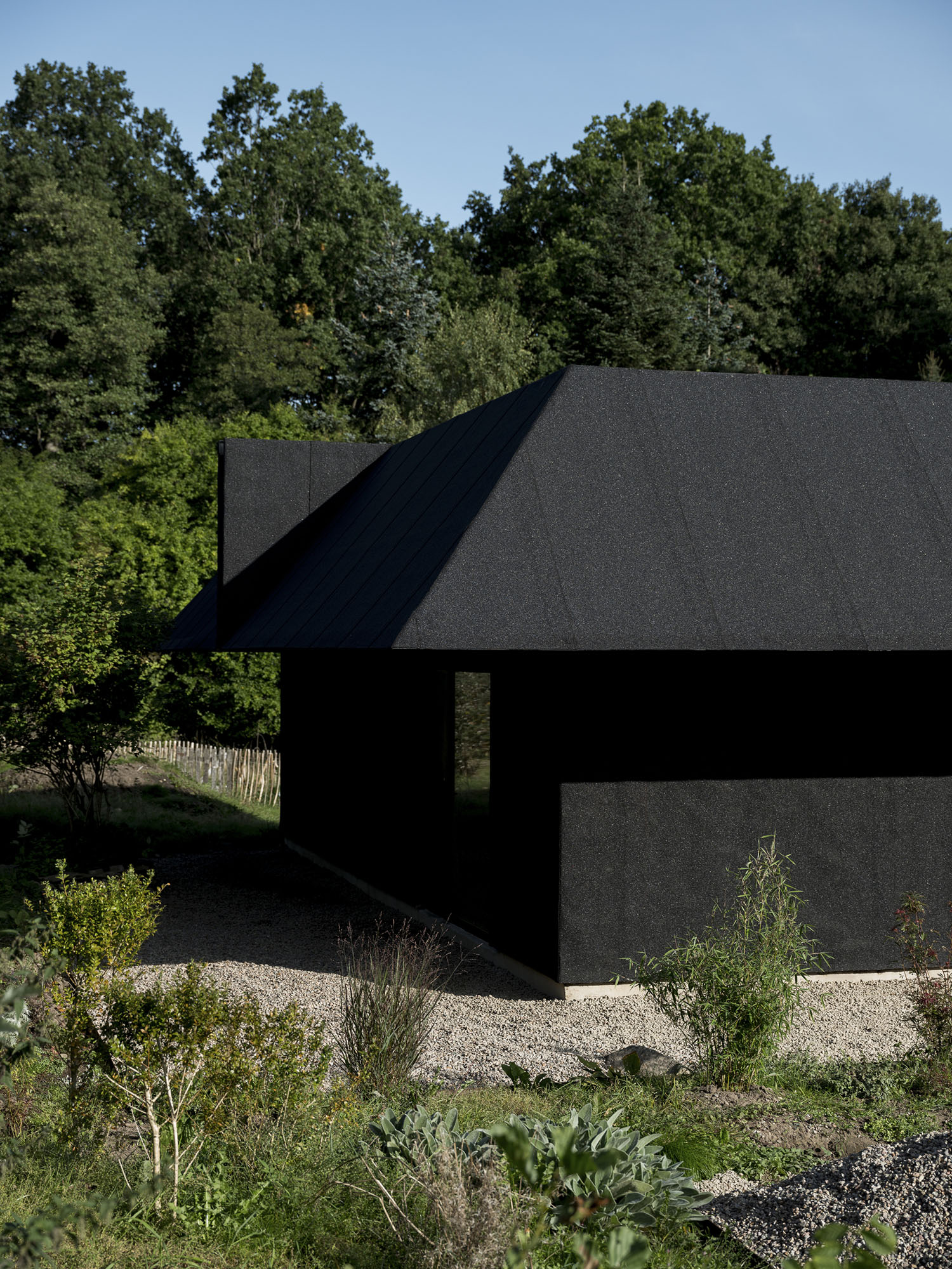 House for Two Artists by Förstberg Ling — The House for Two Artists presents itself as a dark, rectilinear volume set against dense forest backdrop.