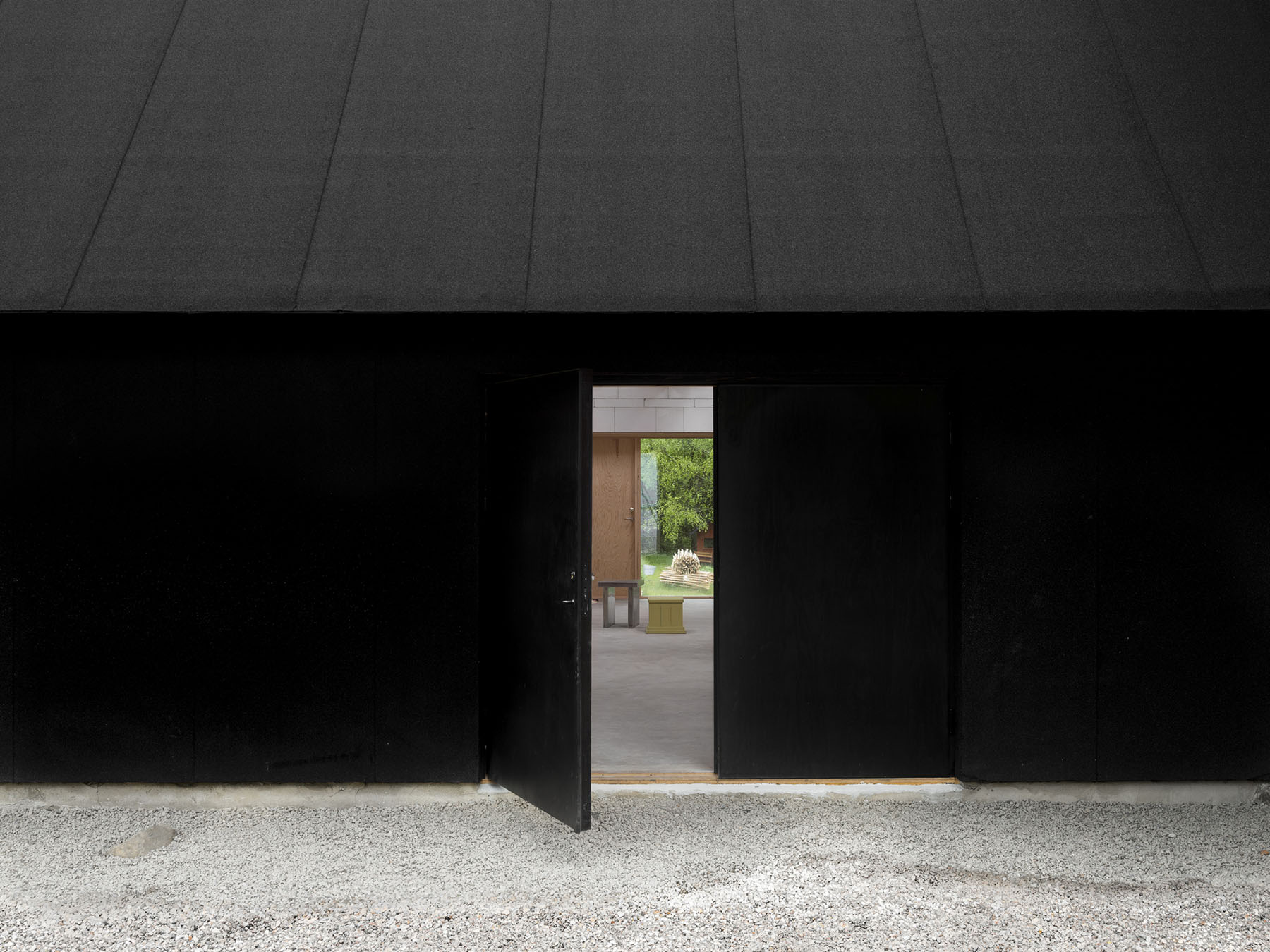 House for Two Artists by Förstberg Ling — A timber-framed passage articulates the threshold between interior atelier and exterior courtyard.