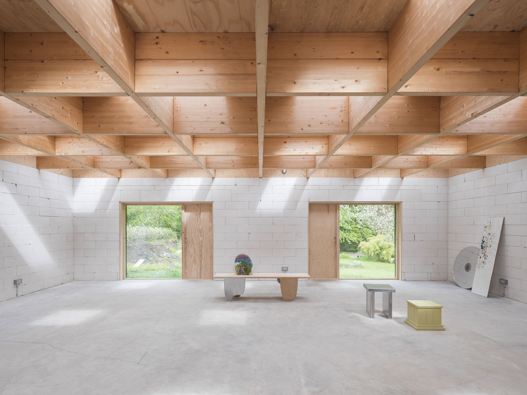 House for Two Artists by Förstberg Ling — The atelier interior reveals the structural logic of Förstberg Ling's design through a coffered ceiling grid formed by free-spanning glulam beams with...