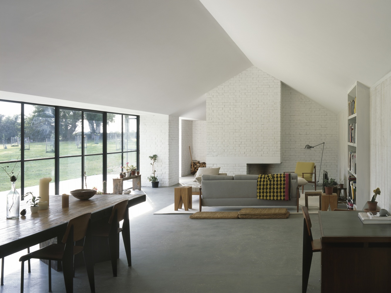 Stable Acre House by David Kohn — The open-plan interior reveals the volumetric brick pavilion that anchors the composition, its white-painted masonry wall rising through the pitched roof...