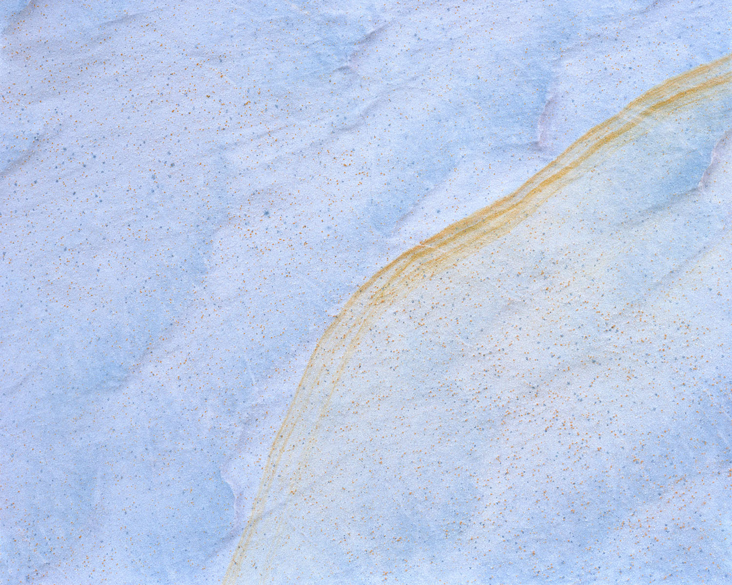 Breathtaking Landscapes by Luca Tombolini — Overhead photograph of water-sculpted mineral terrain where parallel striations in stratified rock create diagonal linear patterns across the frame.