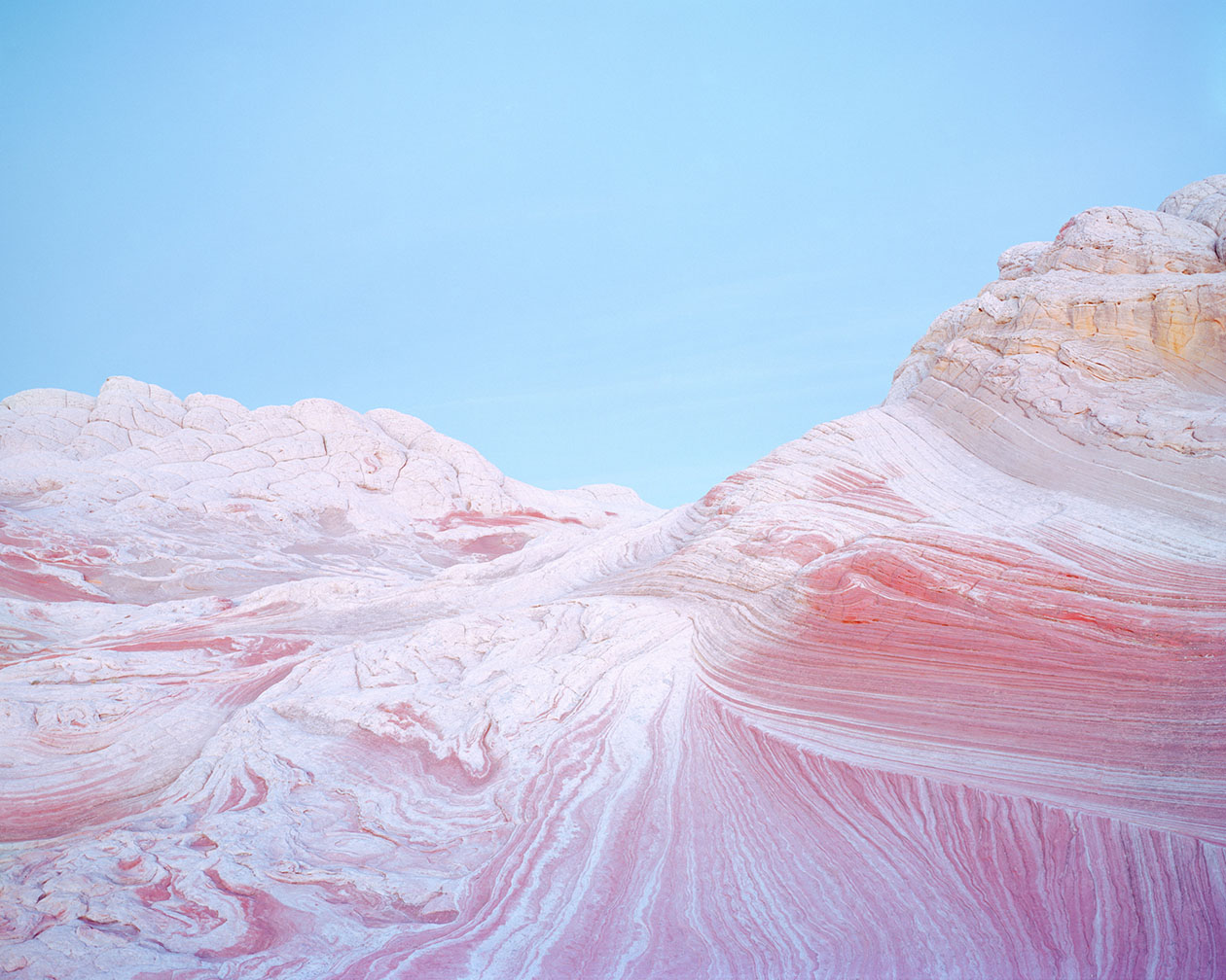 Breathtaking Landscapes by Luca Tombolini — Folded rhyolite formations dominate this large-format landscape, revealing dramatic chromatic banding in rust-red, cream, and pale ochre across diagonal...
