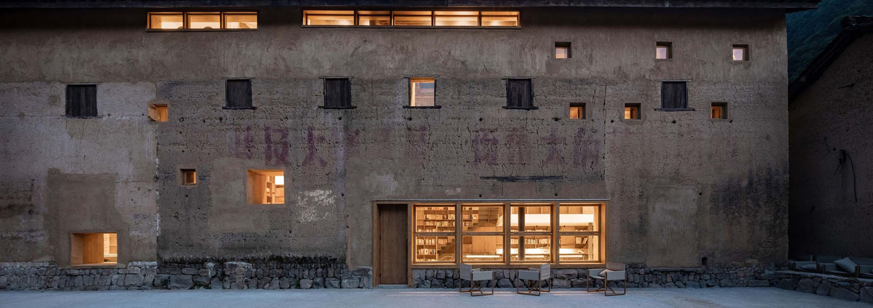 Capsule Hotel and Bookstore in Village Qinglongwu by Atelier tao+c — A renovated village building in Zhejiang integrates a capsule hotel and bookstore within a historic two-story timber and mud-wall structure.