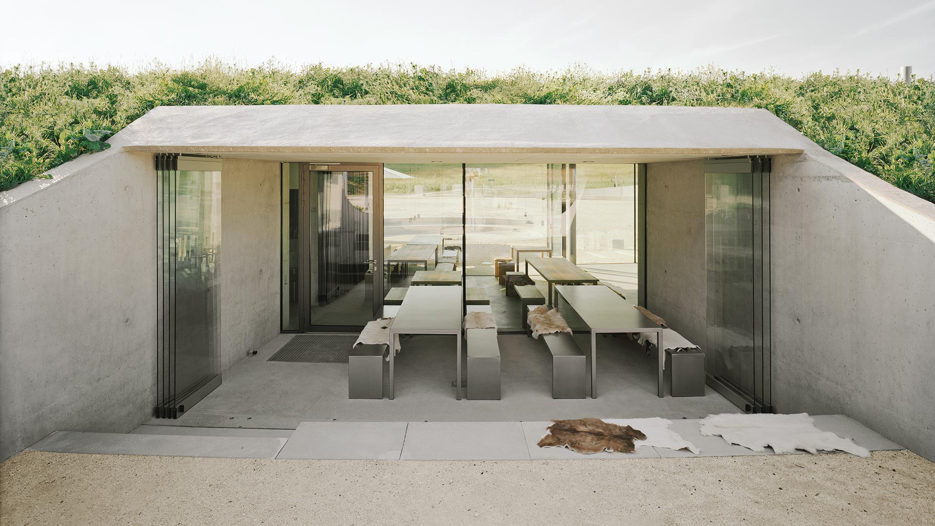 Information Center Archäopark Vogelherd by Ritter Jockisch Architects — A glazed foyer elevation reveals the building's partial subterranean insertion into the hillside.