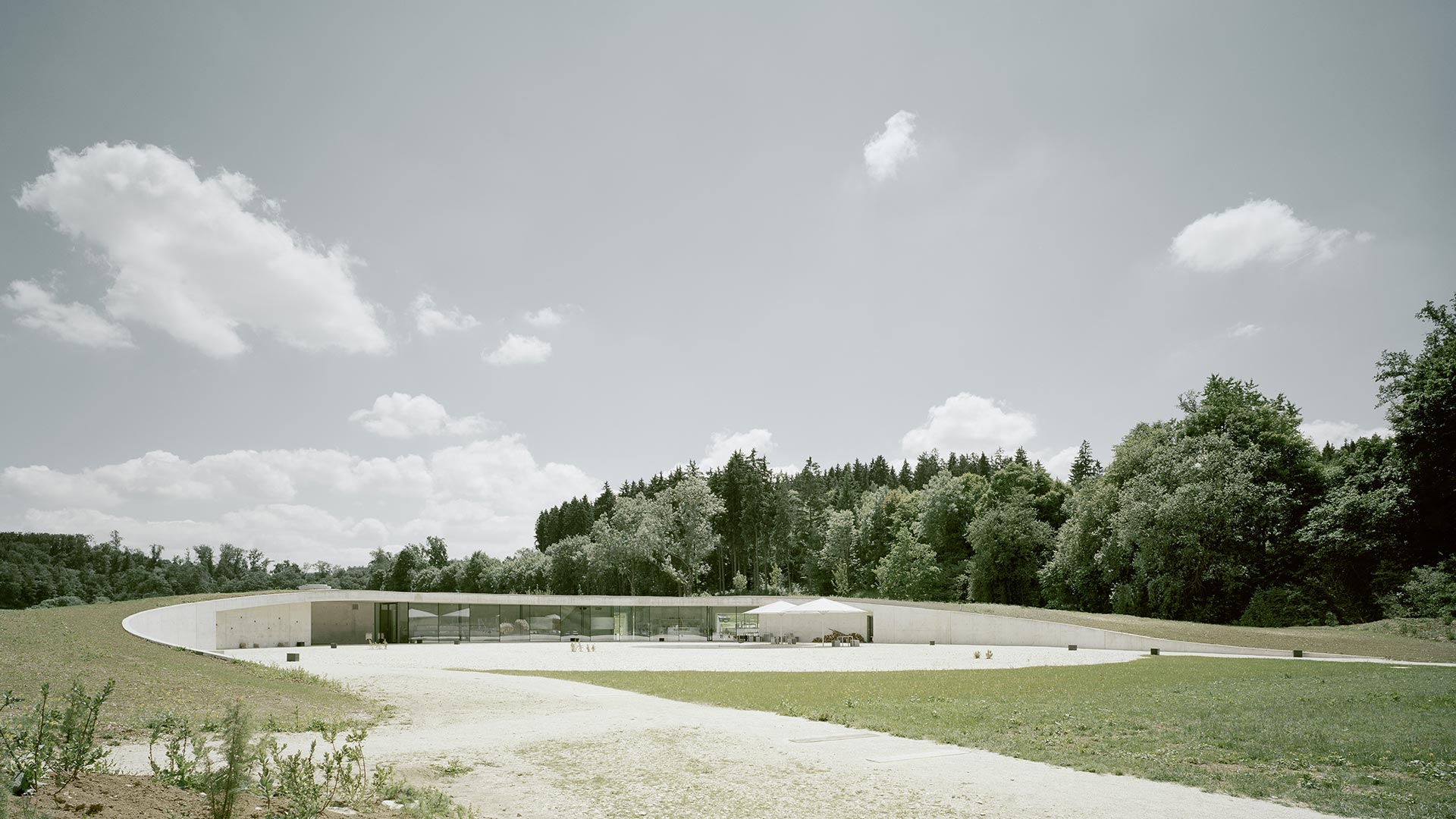 Information Center Archäopark Vogelherd by Ritter Jockisch Architects — The Information Center Archäopark Vogelherd presents itself as a linear pavilion emerging from a sloped earthen berm.