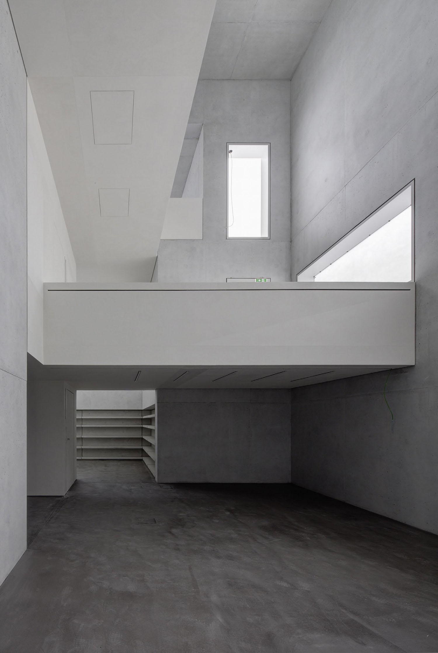 Neue Meisterhäuser Bauhaus Dessau by Bruno Fioretti Marquez — Double-height interior space with monolithic concrete construction defining two distinct levels.