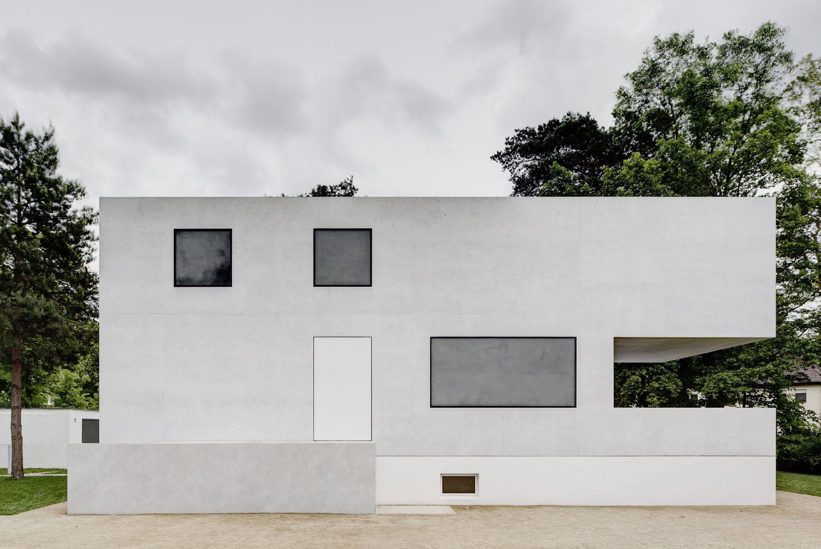 Neue Meisterhäuser Bauhaus Dessau by Bruno Fioretti Marquez — The front elevation of the reconstructed Meisterhäuser demonstrates a rigorous geometric vocabulary through recessed square windows that cast shadow-line...