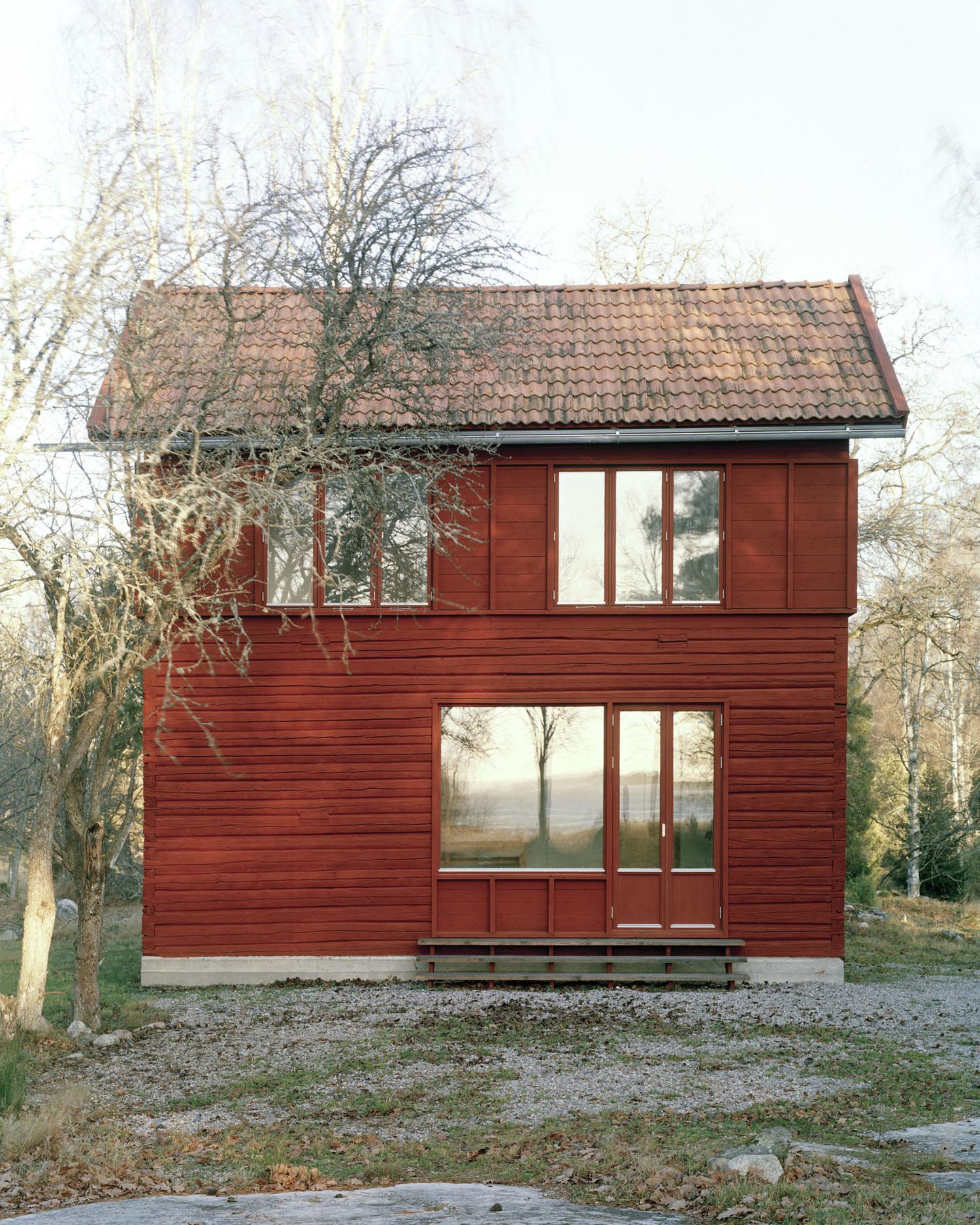Nannberga Summer House by General Architecture — A compact timber-clad summer house photographed from the front elevation, revealing its modest two-story typology.