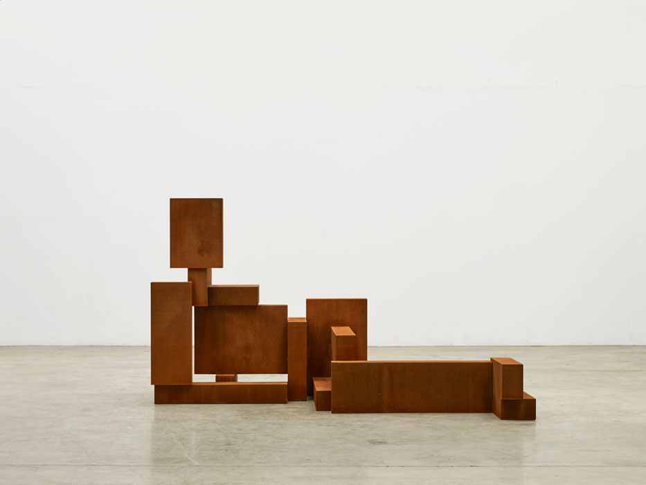Sculptures by Antony Gormley — Timber blocks of varying dimensions assembled into an abstracted human figure, arranged across a polished concrete floor.