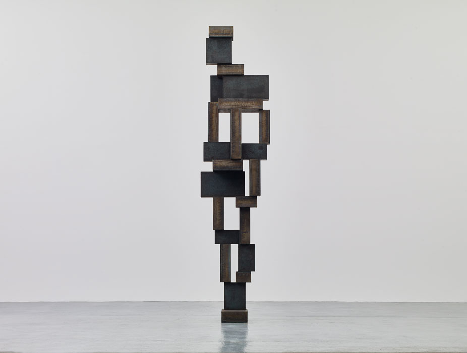 Sculptures by Antony Gormley — Vertical timber sculpture constructed from rectangular blocks of varying dimensions stacked in an irregular, voxelated arrangement that suggests human form...