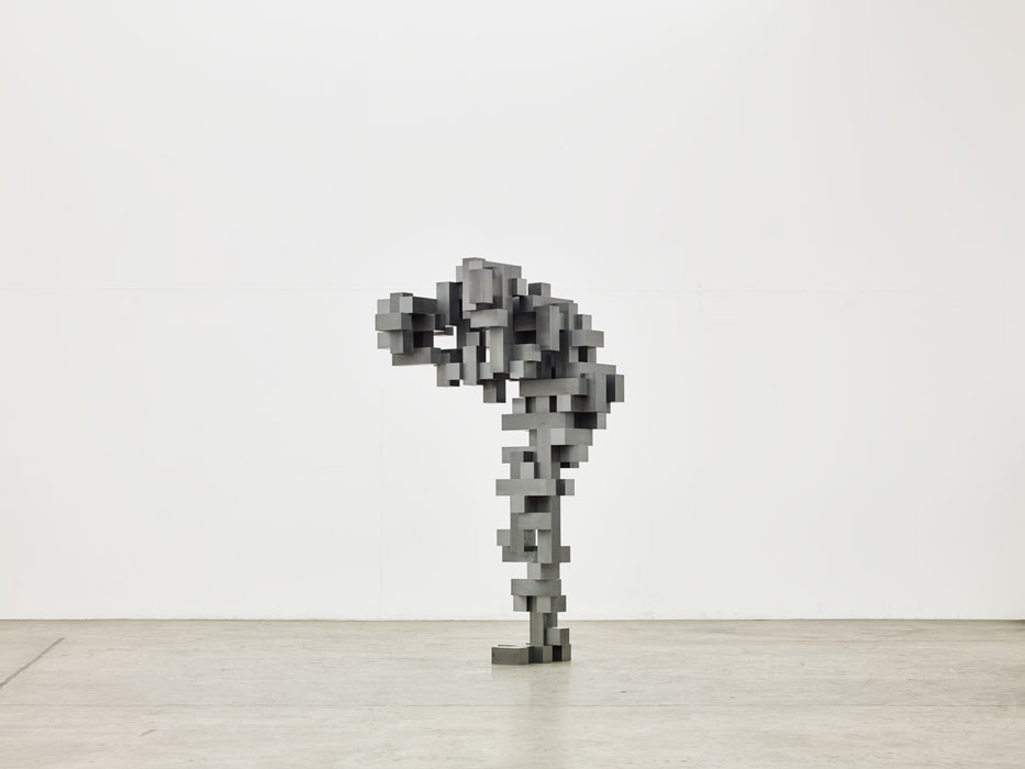 Sculptures by Antony Gormley — A timber sculpture constructed from rectangular blocks of varying dimensions, stacked to suggest human form in a forward-bending posture.
