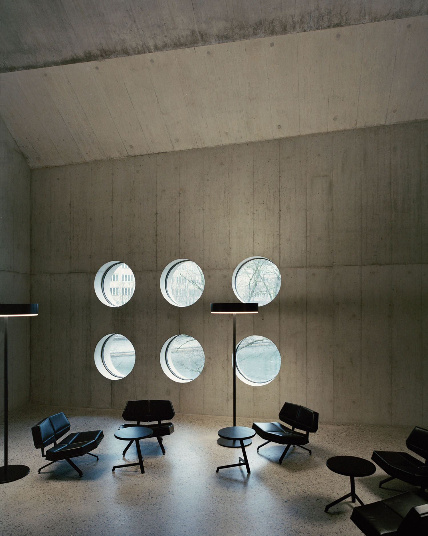 Swiss National Museum by Christ & Gantenbein photographed by Rory Gardiner — Interior view of Christ & Gantenbein's Swiss National Museum extension showcasing six circular skylights arranged in two rows across a board-formed concrete...