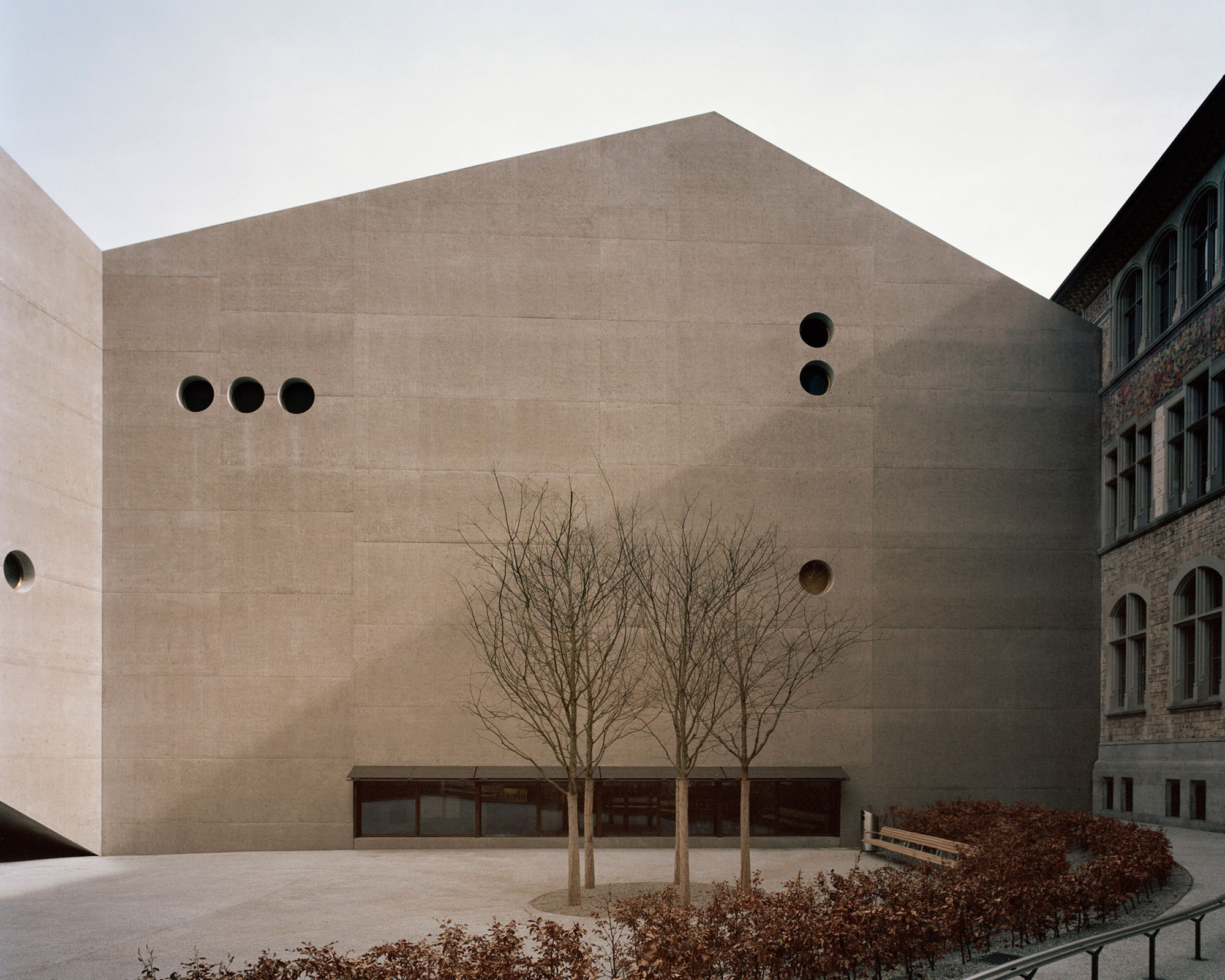 Swiss National Museum by Christ & Gantenbein photographed by Rory Gardiner — Christ & Gantenbein's cream-colored concrete extension to the Swiss National Museum presents a monolithic facade punctuated by four circular perforations...
