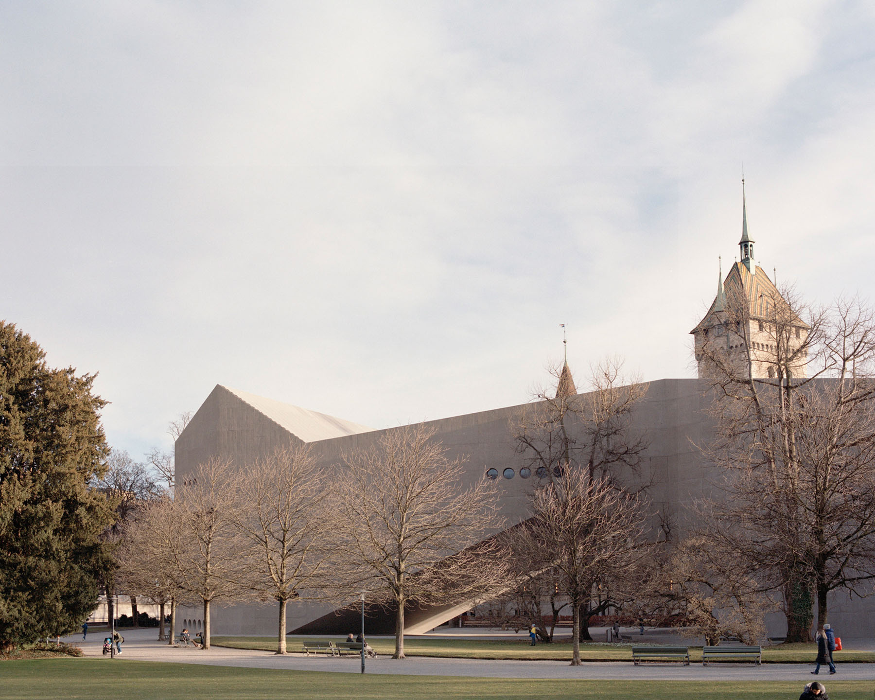Swiss National Museum by Christ & Gantenbein photographed by Rory Gardiner — The new Christ & Gantenbein wing anchors the museum courtyard with its monolithic cream concrete facade, punctuated by four circular perforations arranged...