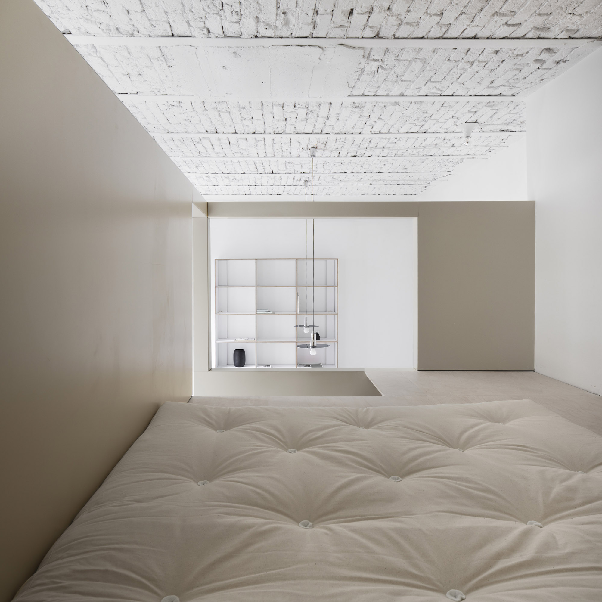 A-PLACE K907 by Thisispaper Studio — A mezzanine bedroom viewed from the bed, with whitewashed timber ceiling exhibiting herringbone planking and visible nail marks overhead.