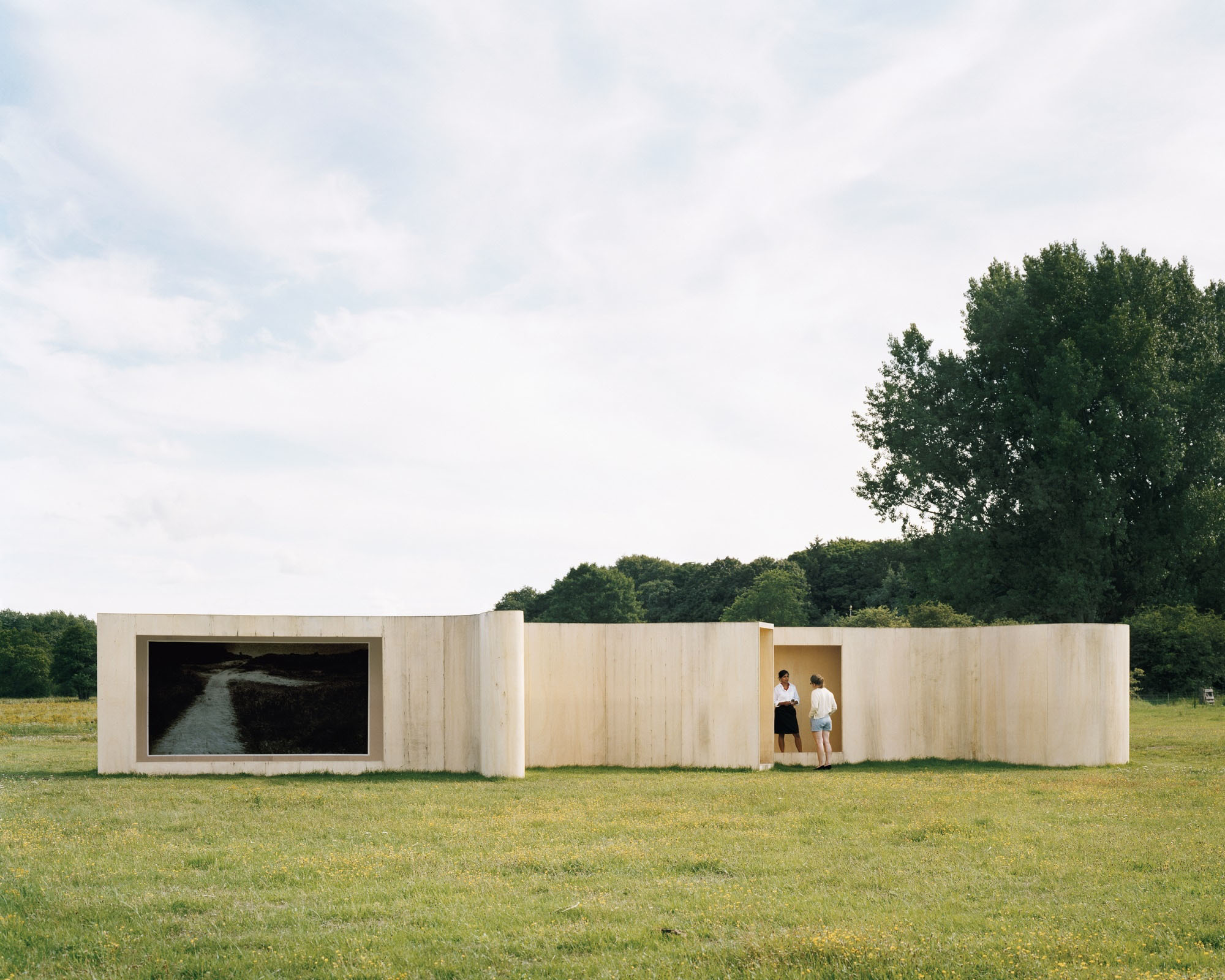Temporary Museum (Lake) by Anne Holtrop — Anne Holtrop's temporary concrete pavilion frames a landscape view through a large rectangular aperture cut into its left facade, revealing a water channel...