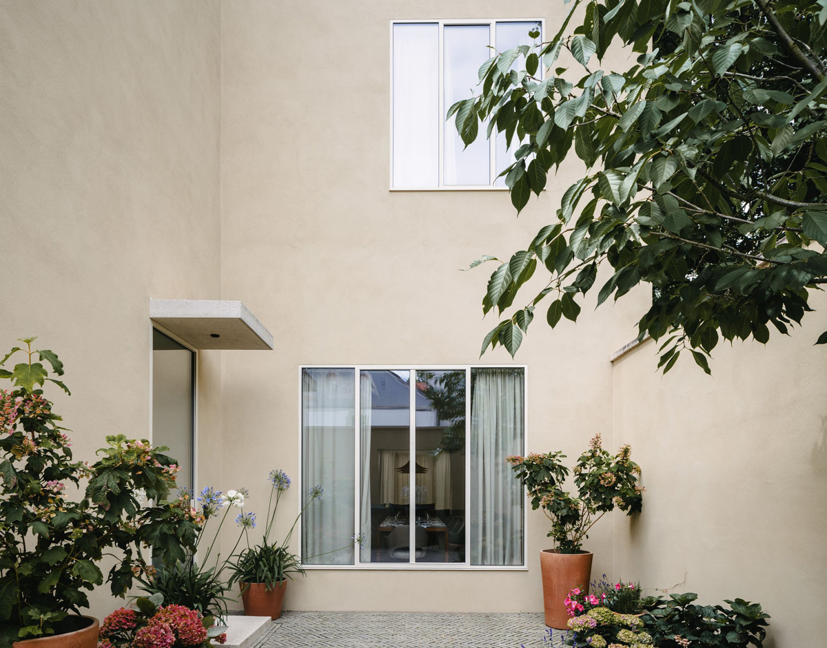 Bogenhausen House by David Chipperfield Architects — The rear garden elevation of Bogenhausen House presents a measured composition of large-format glazing and rendered plaster.