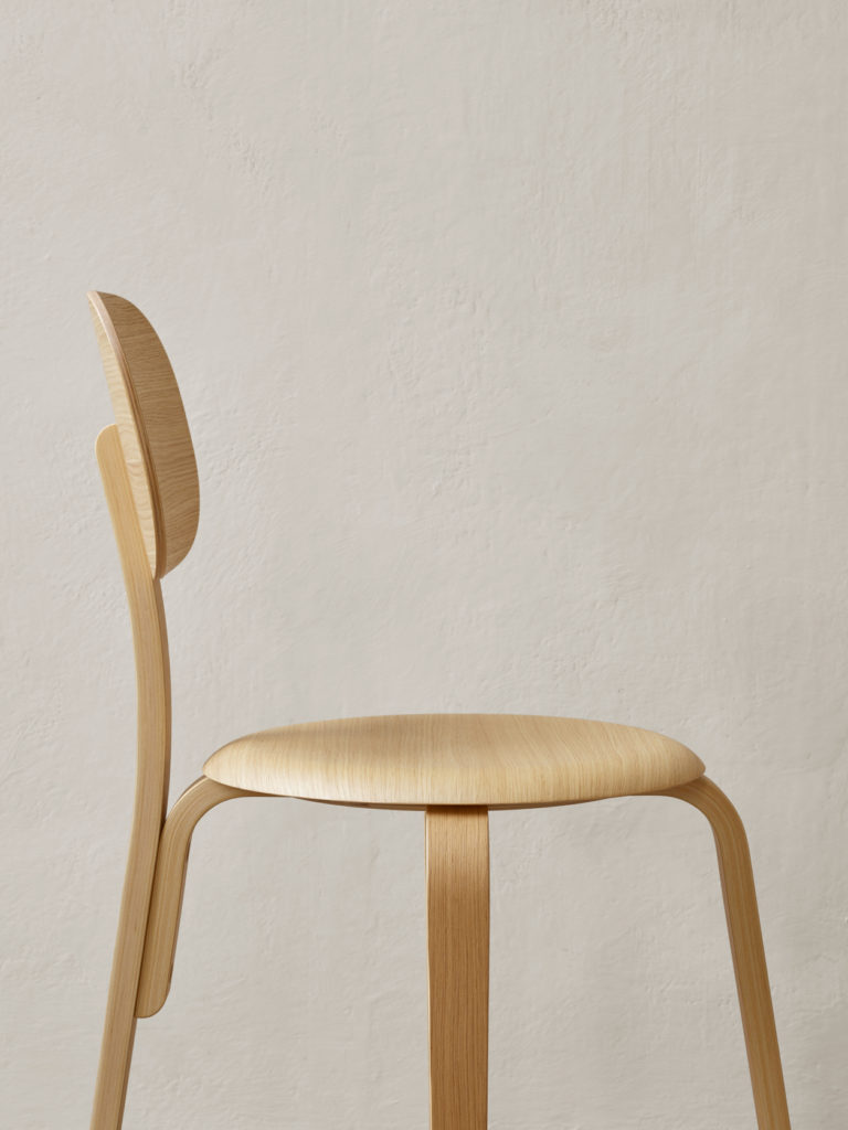Dining Chair Plus by Afteroom — A side-profile photograph isolates Afteroom's Dining Chair Plus against a neutral plaster wall, emphasizing its sculptural geometry.