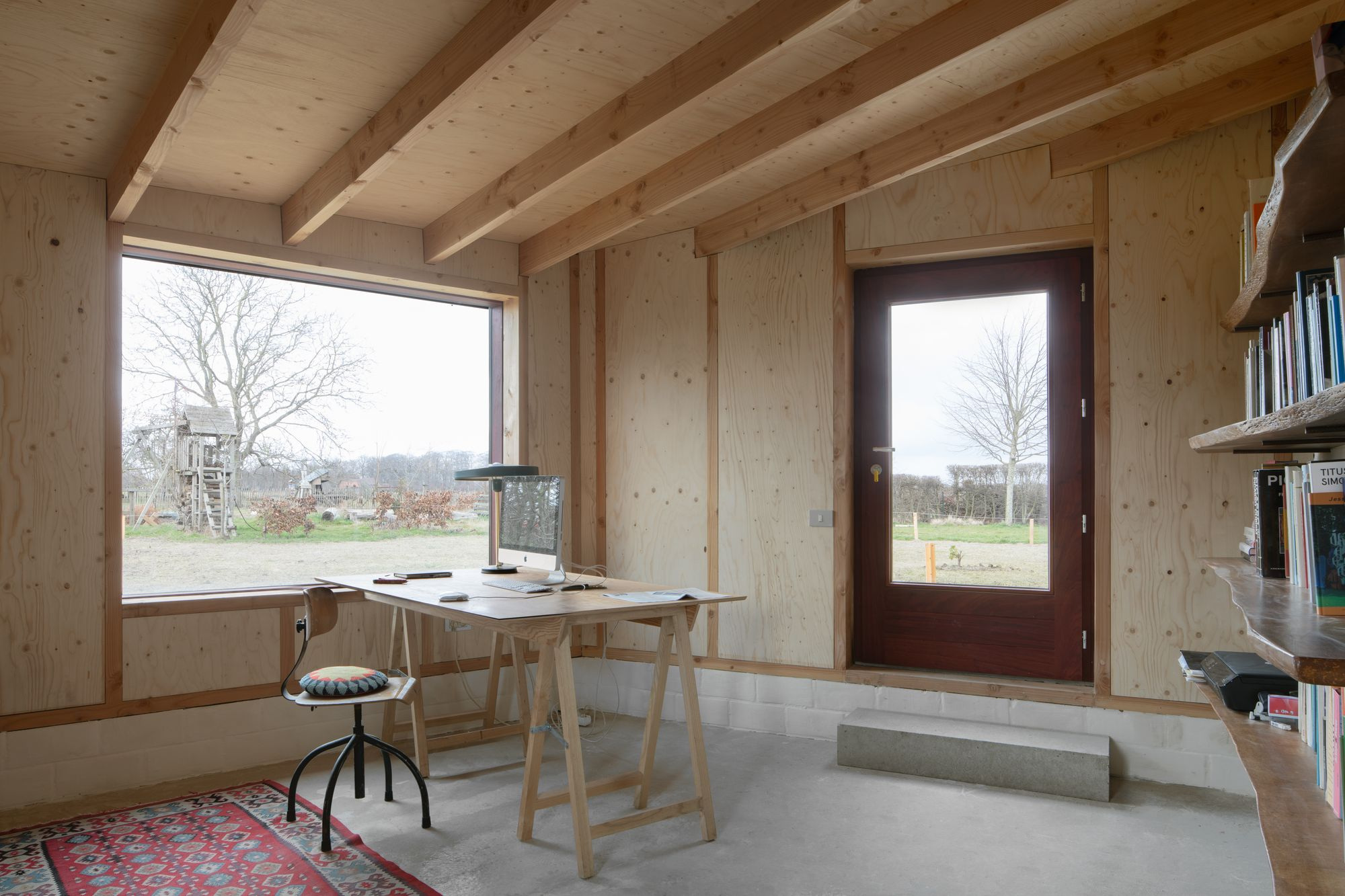 Studio SDS by GRAUX & BAEYENS — A workspace bathed in daylight from a horizontal window with deep grey concrete lintel.