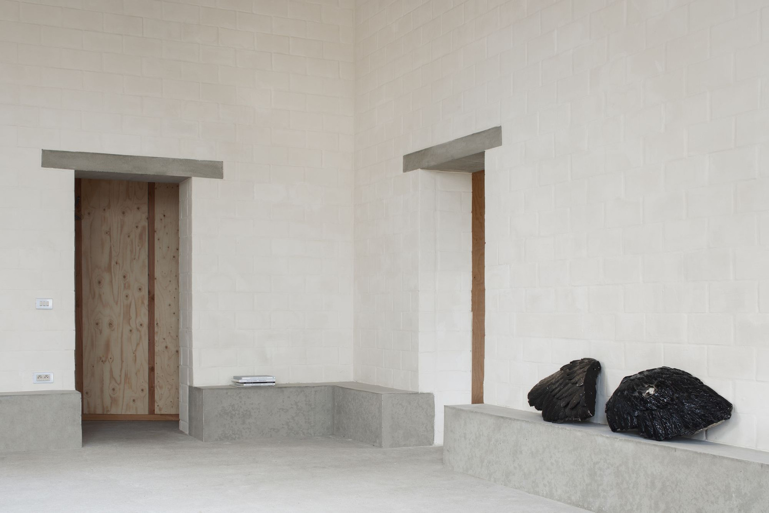 Studio SDS by GRAUX & BAEYENS — The studio interior presents a minimalist threshold space defined by concrete construction and material contrast.