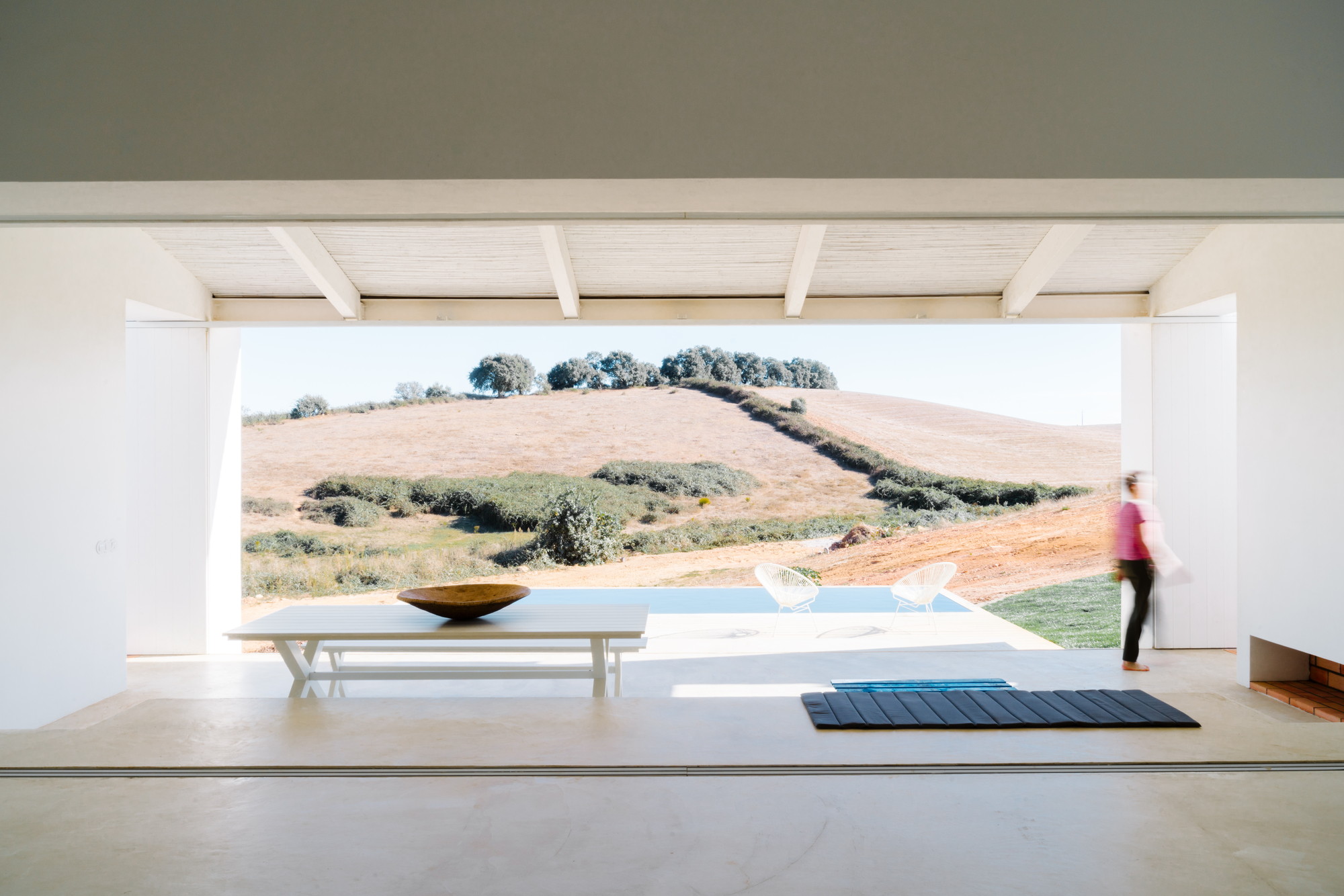 Cercal House by Atelier Data — A deep interior space frames the rolling Alentejo landscape through a massive open threshold.