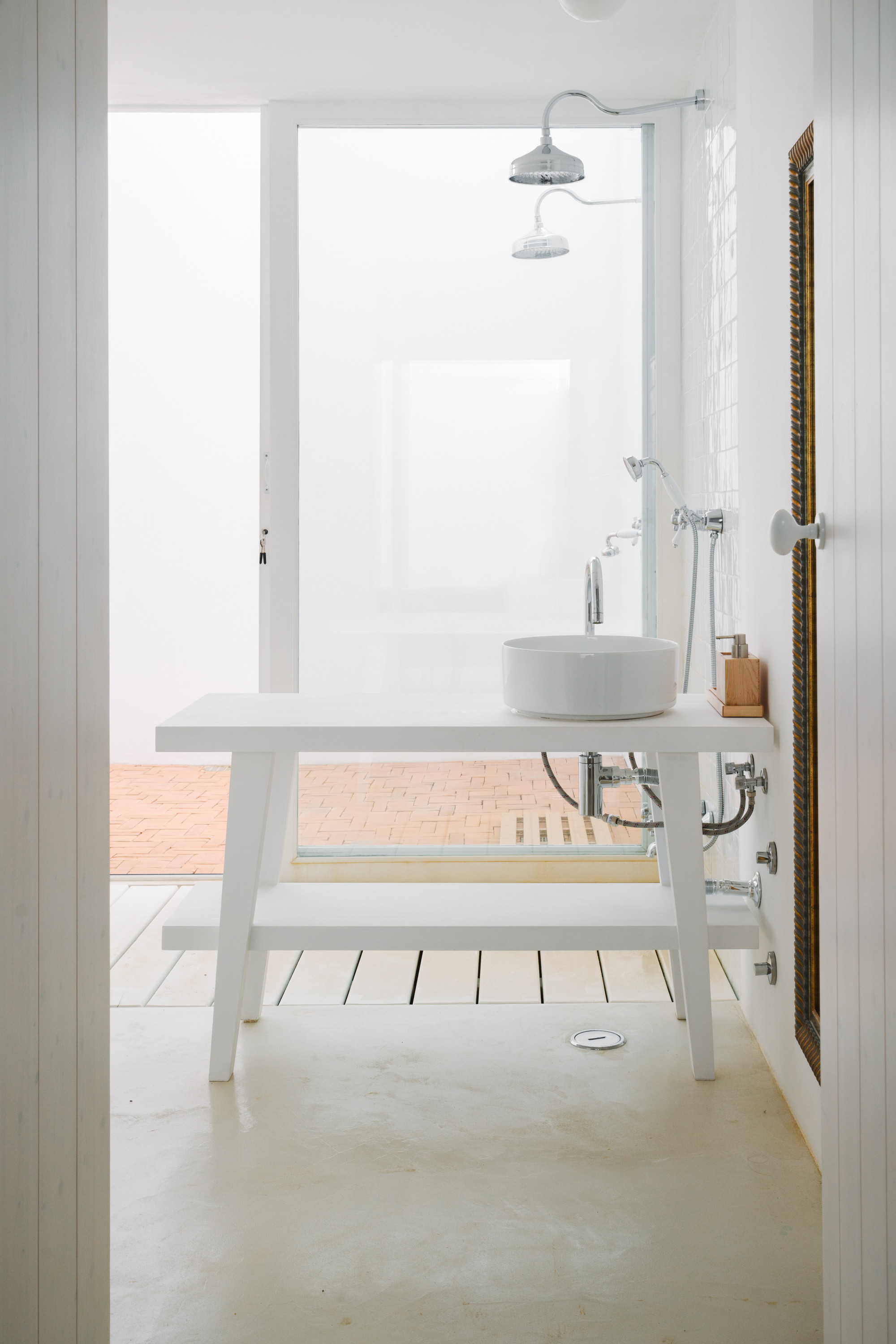 Cercal House by Atelier Data — A bathroom interior featuring a minimalist white palette and open spatial arrangement.