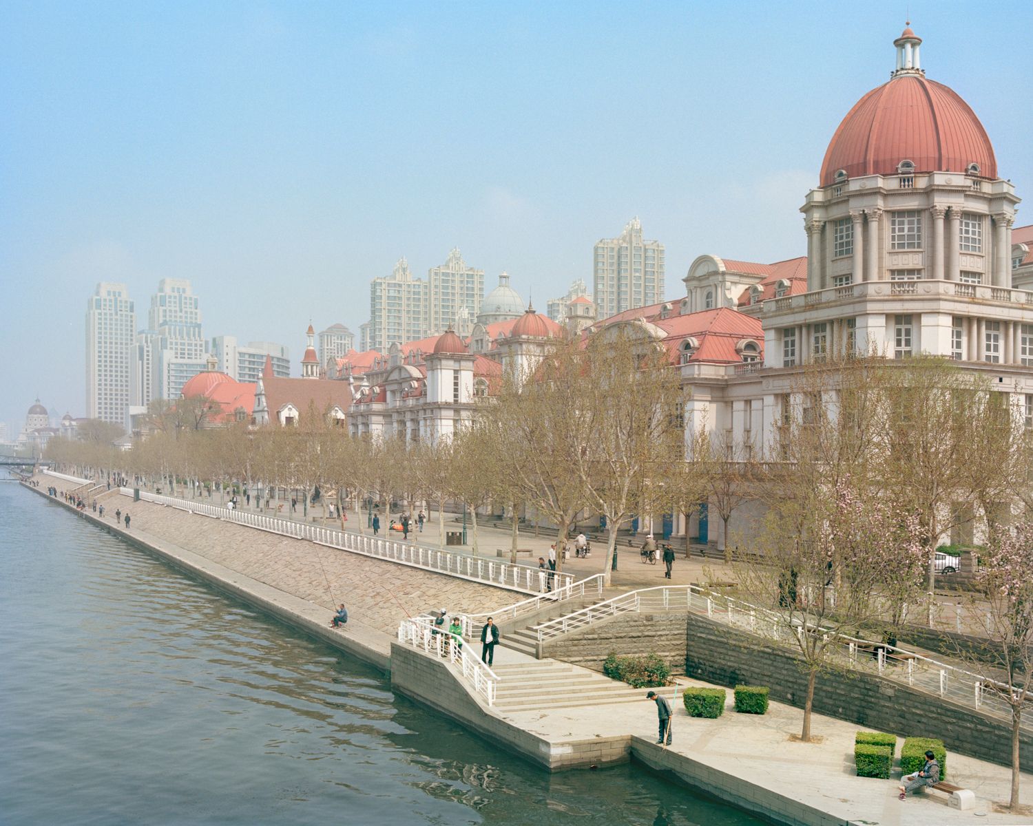 I am just a scenic spot by Pauilne Niks — A waterfront promenade frames a reconstructed fortification wall with stone crenellations and wide staircase access.