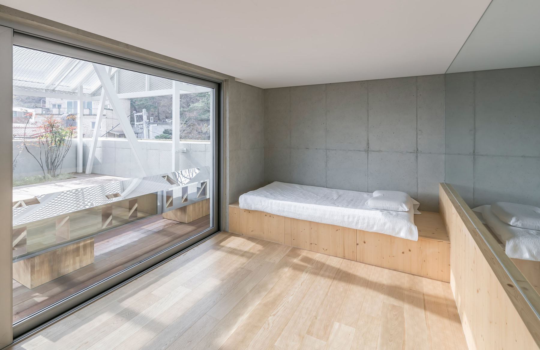 The Shaded Rooftop House by BCHO Architects — A bedroom within the Shaded Rooftop House reveals the interior consequences of the project's modular light-diffusion system.