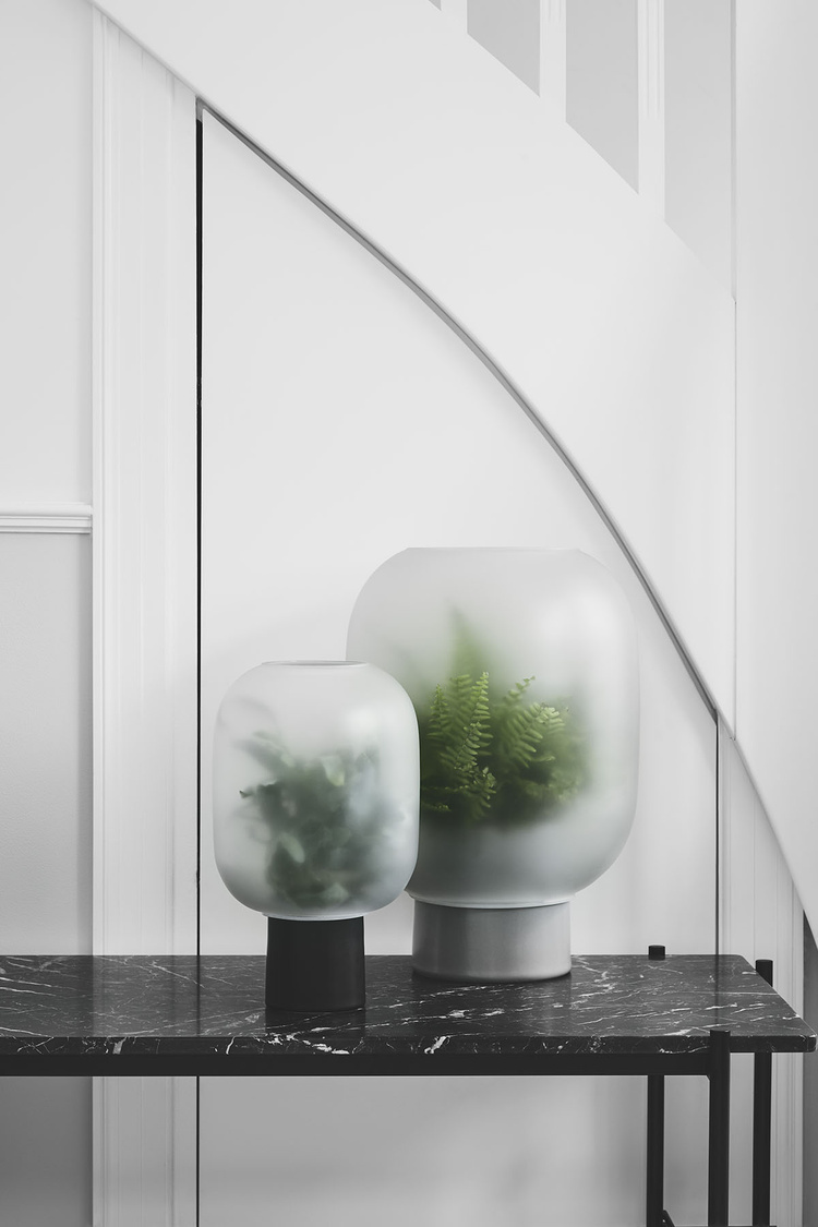 Nebl by Studio Rem — Nebl planters arranged on a black marble table against white paneled walls.