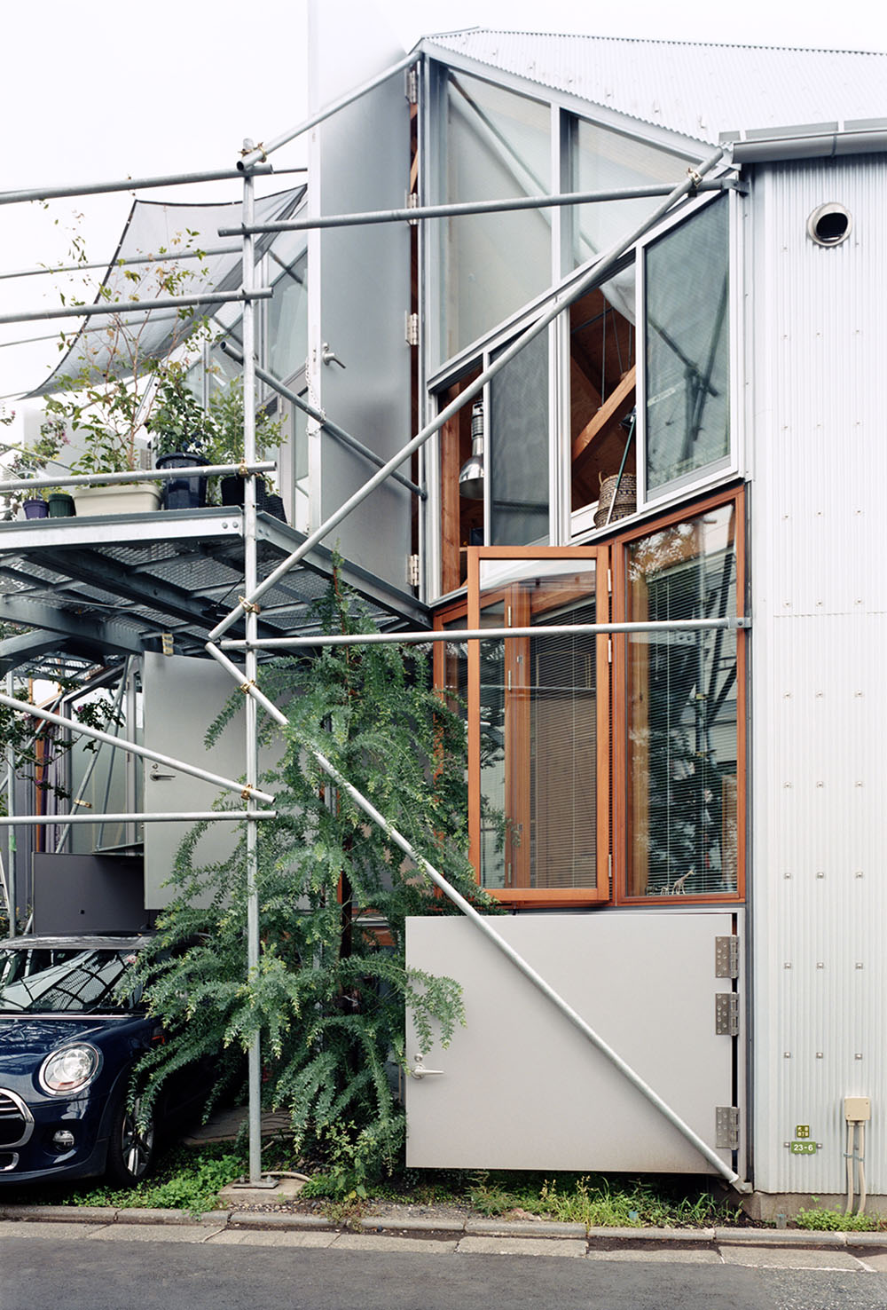 Daita2019 House by Suzuko Yamada Architects — The street facade of Daita2019 House presents an intricate steel framework system dominating the three-story elevation.