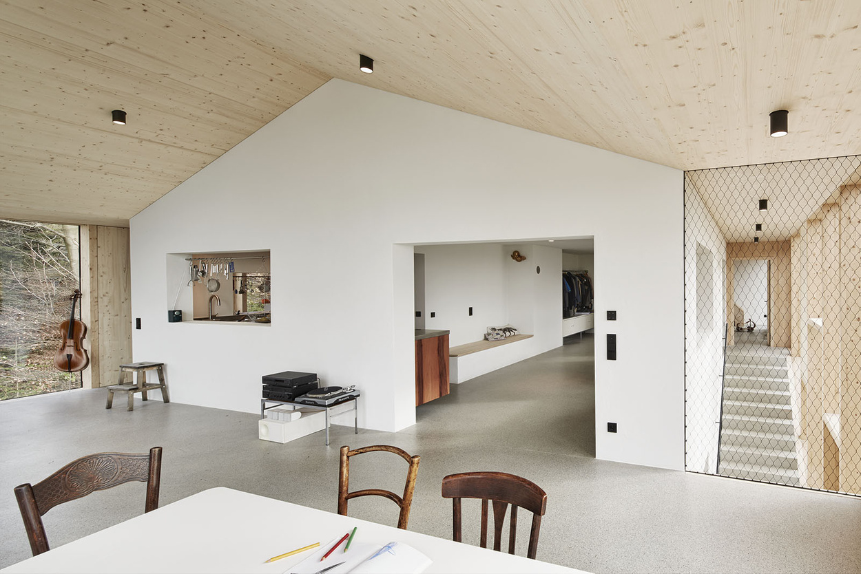 House Hohlen by Jochen Specht — Interior view of the renovated House Hohlen showing the open-plan living space beneath the pitched timber ceiling.