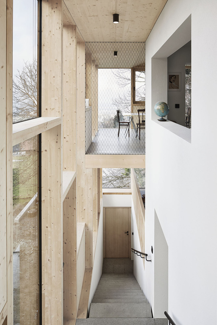 House Hohlen by Jochen Specht — A vertical passage connects the recessed ground level to the upper timber-clad volume.