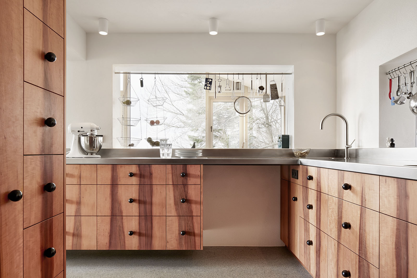 House Hohlen by Jochen Specht — Interior kitchen view framed by the large gridded window system overlooking the Austrian valley landscape.