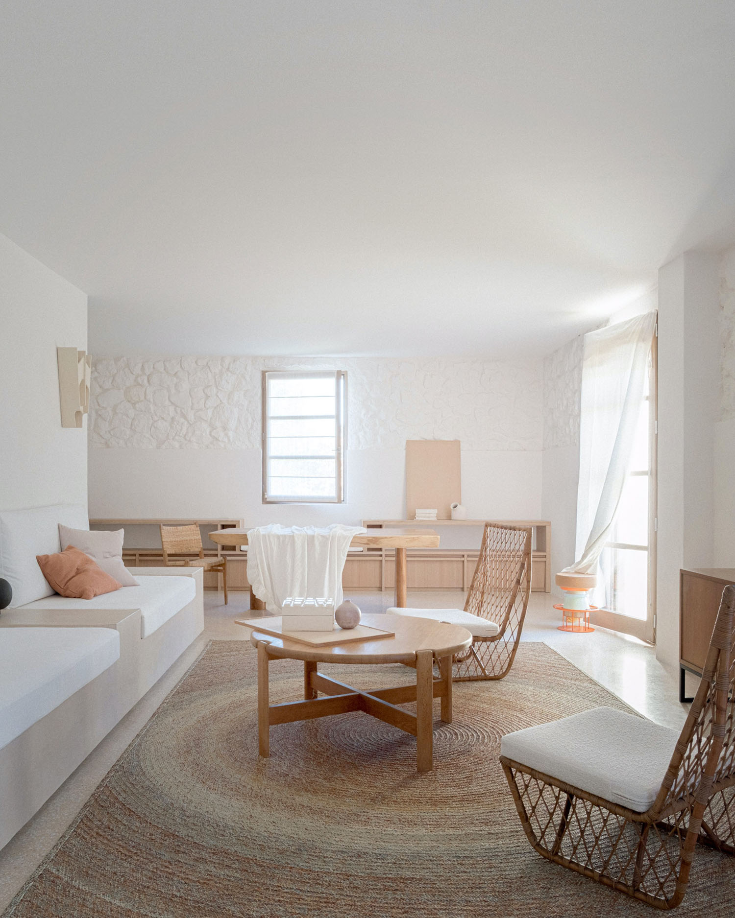 MA House by Studio XM — Interior living space featuring a minimalist palette of white, cream, and natural wood tones.