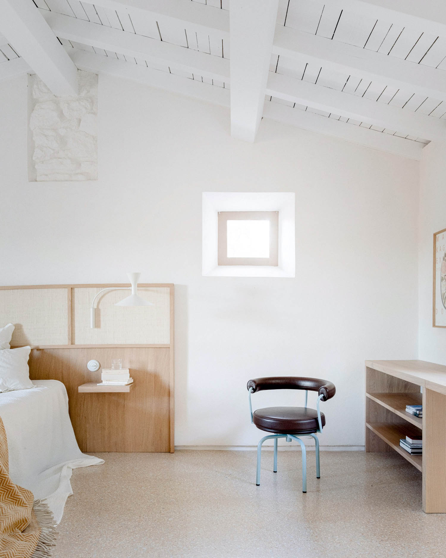 MA House by Studio XM — A bedroom interior with pitched ceiling exposing metal rods and white-painted timber framework.