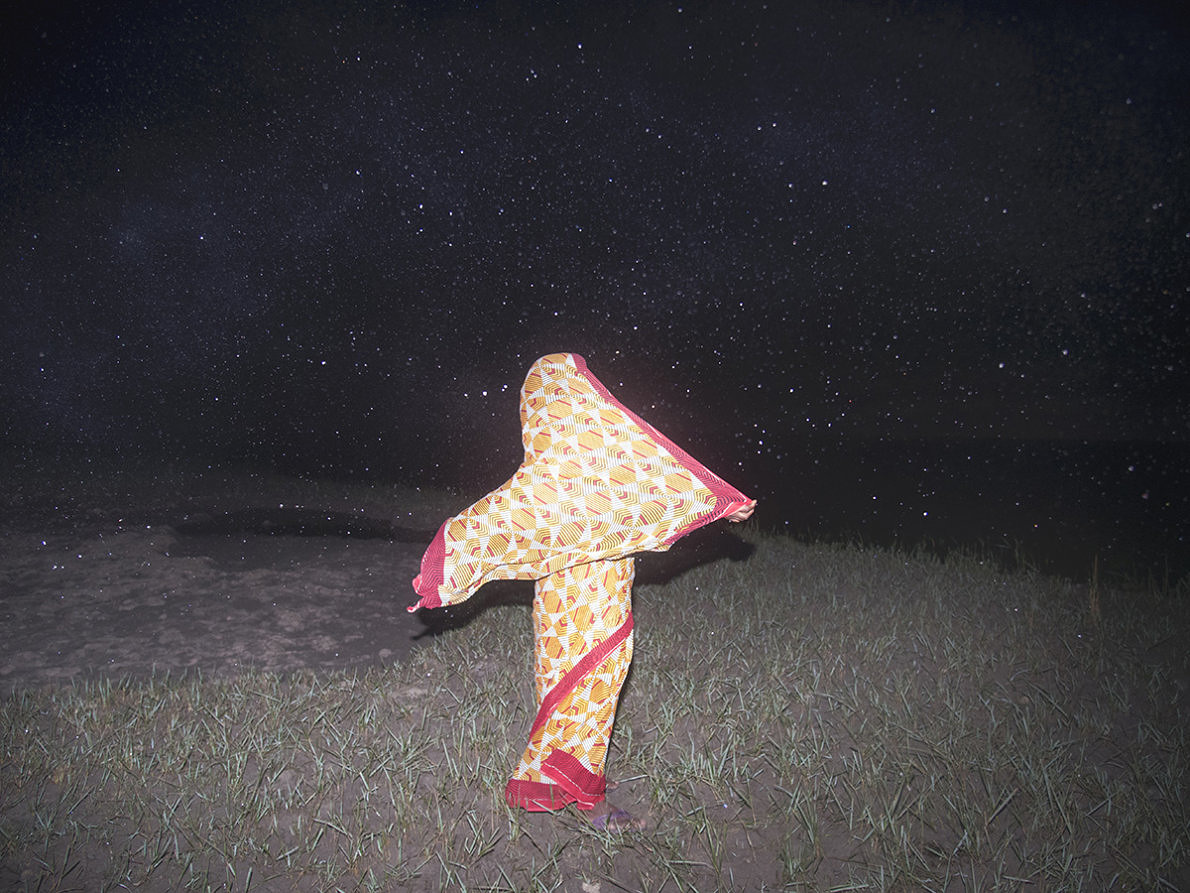Ebbing away of Identity with the Tides by Sushavan Nandy — A fabric form positioned on darkened ground beneath a starlit sky.