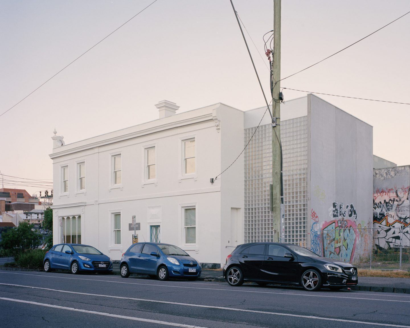 Yoga Studio by Richard Stampton — The street elevation reveals the yoga studio's insertion within a heritage Victorian building, its white rendered facade and regular fenestration...