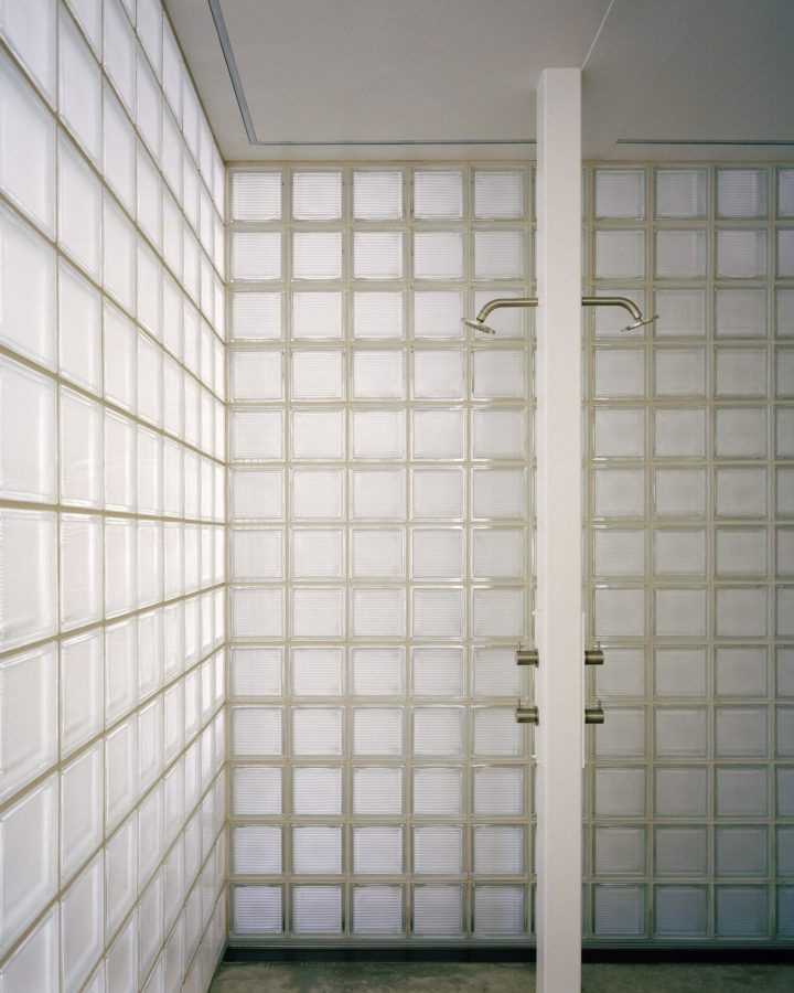 Yoga Studio by Richard Stampton — Glass block walls form the primary architectural feature of this yoga studio corridor, their gridded translucent surfaces diffusing natural light uniformly...
