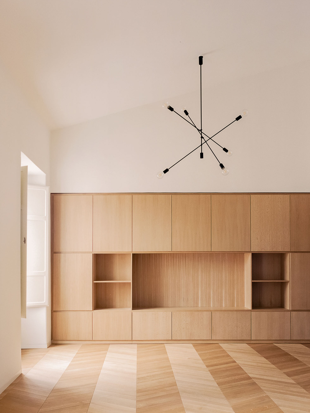 House for a Couple by SET Architects — A residential interior showcasing bespoke timber cabinetry integrated across an entire wall.