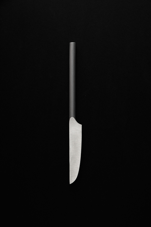 Selected works by Carlo Clopath — A utensil photograph isolating a single implement against a deep black background.