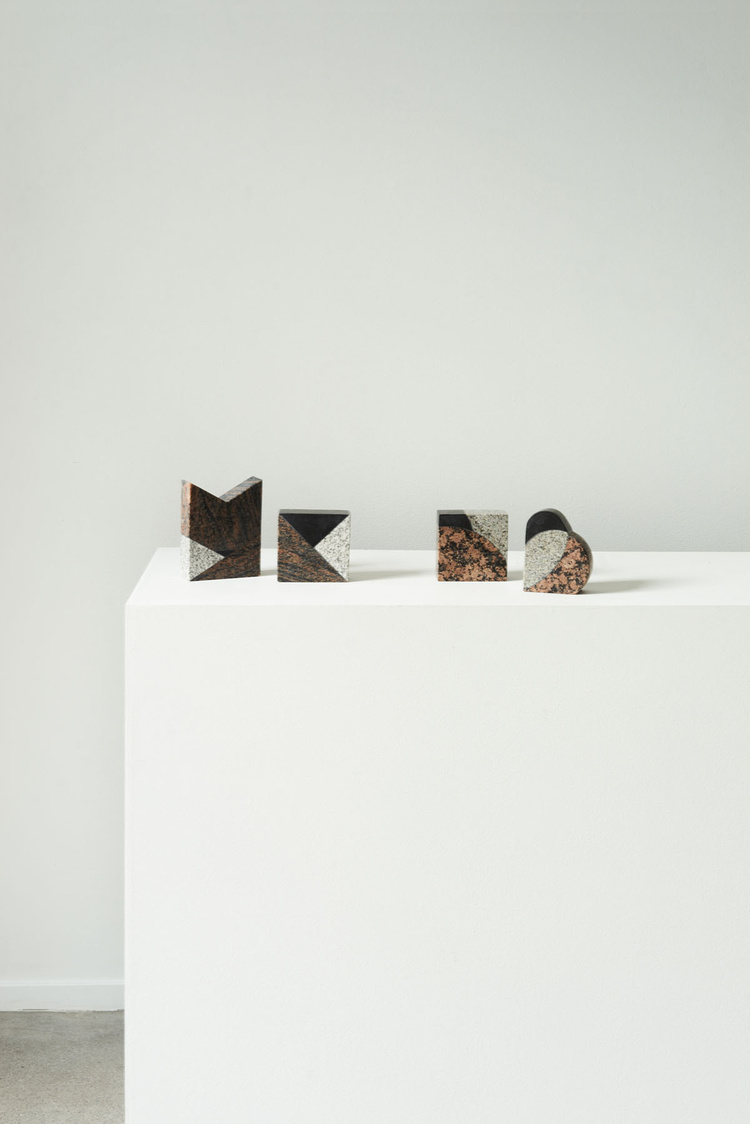Unika Auction by Bjørn van den Berg and Falke Svatun — Four geometric cork and timber objects arranged in sequence across a white lacquered pedestal base.